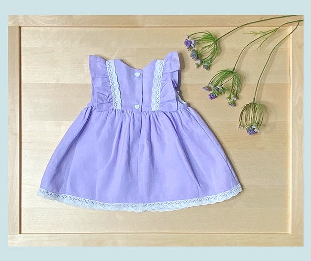 Back view of The Violet lavender linen empire waist dress showing button closure — Alfa Baby Boutique