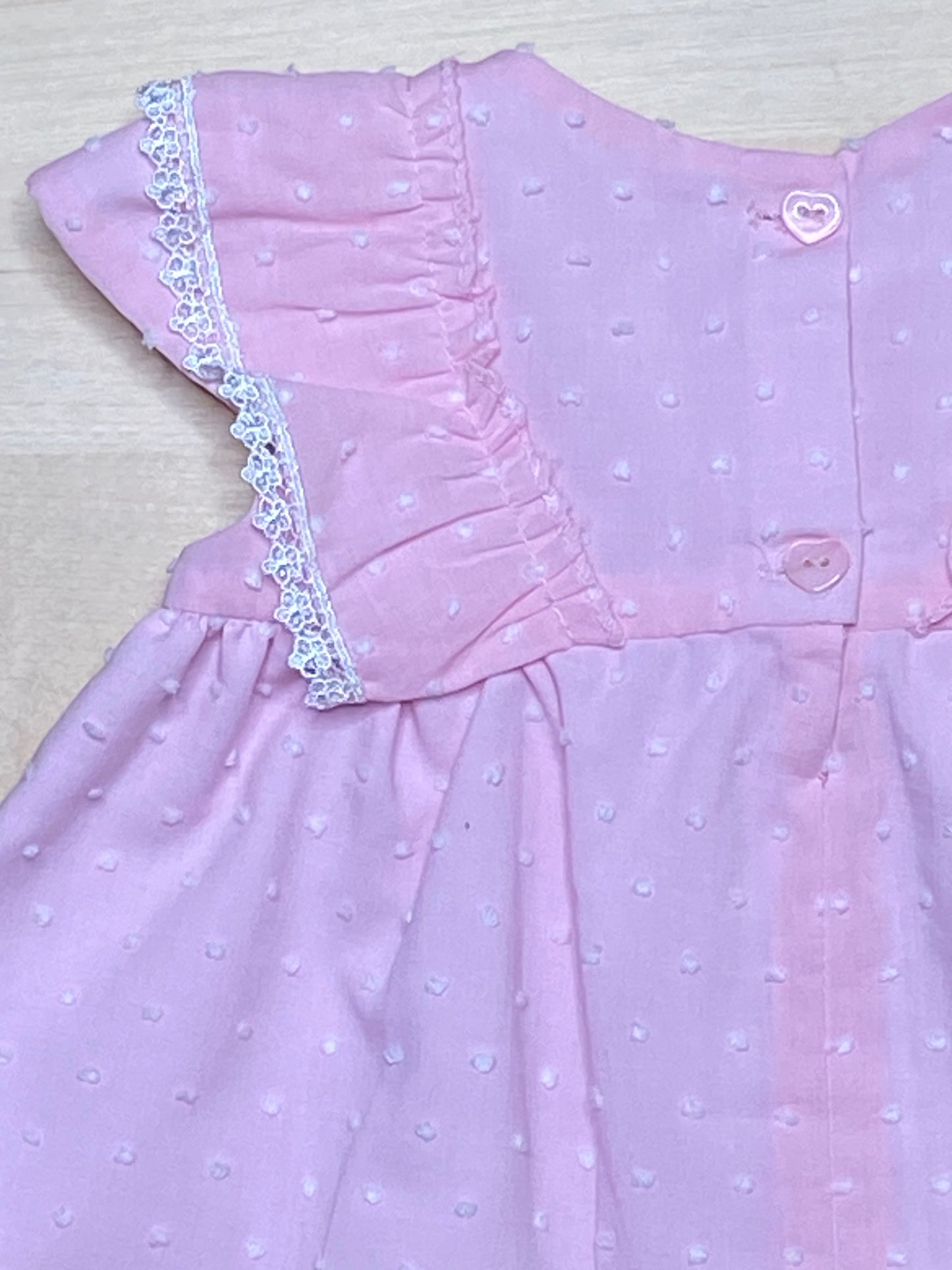Close up back view of The Peony pink Swiss dot dress showing heart-shaped buttons and lace detail-Alfa Baby Boutique 