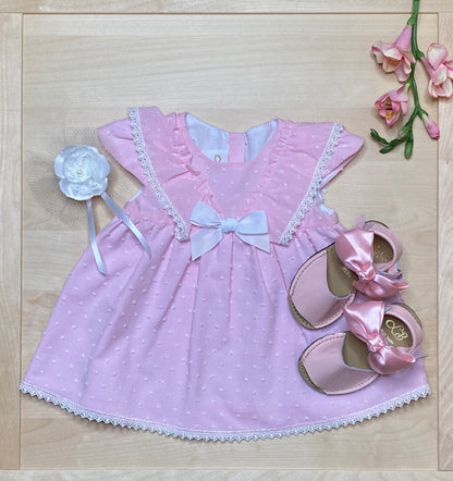 The Peony pink Swiss dot dress and bloomers on light wood background with matching sandals — Alfa Baby Boutique