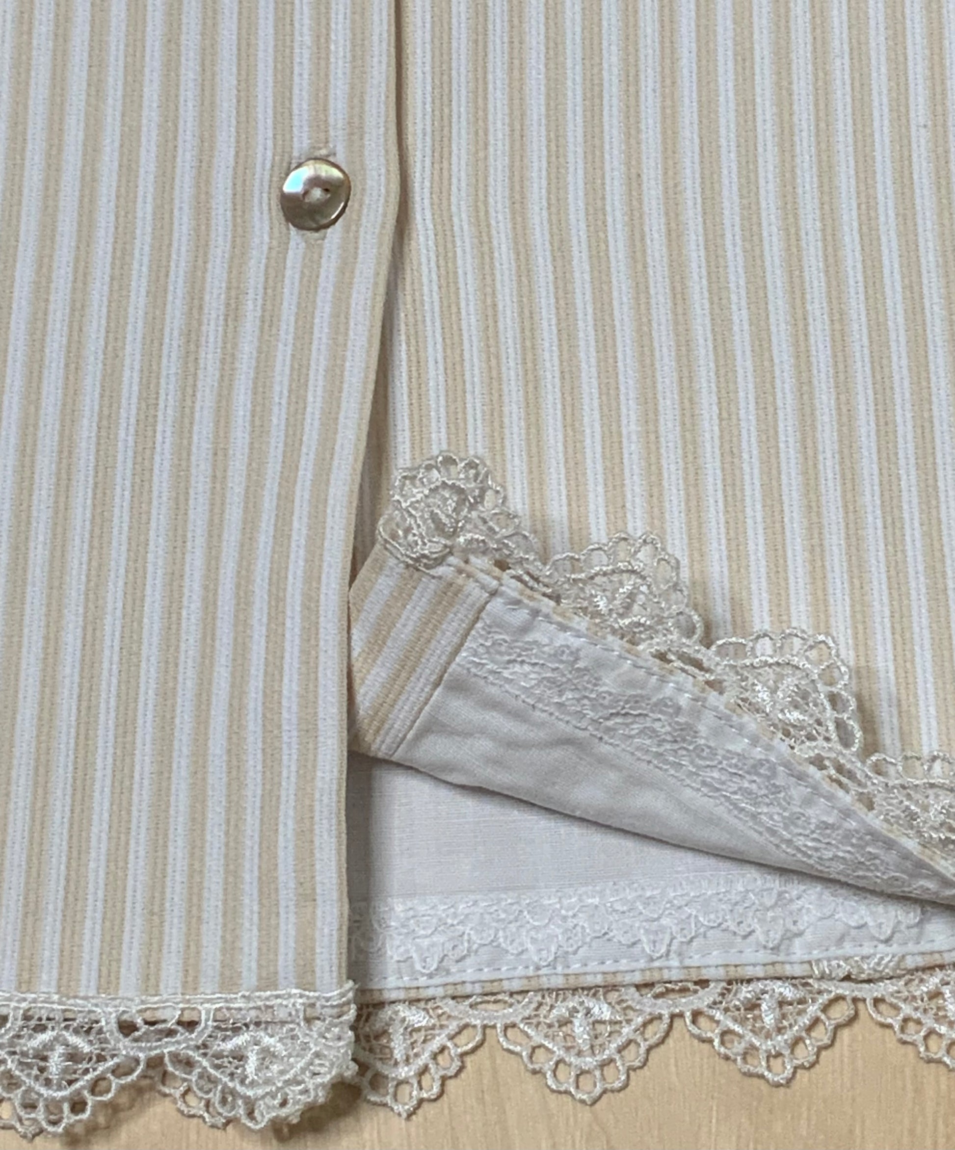 Close-up detail of The Sweet Vanilla lace trim, pearl button, and ivory striped fabric — Alfa Baby Boutique