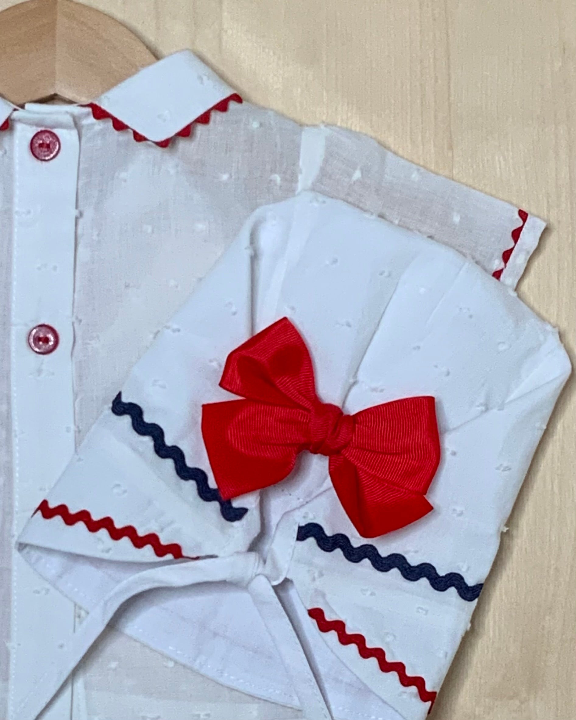 Close-up detail of The Liberty plumeti fabric and red bow trim — Alfa Baby Boutique