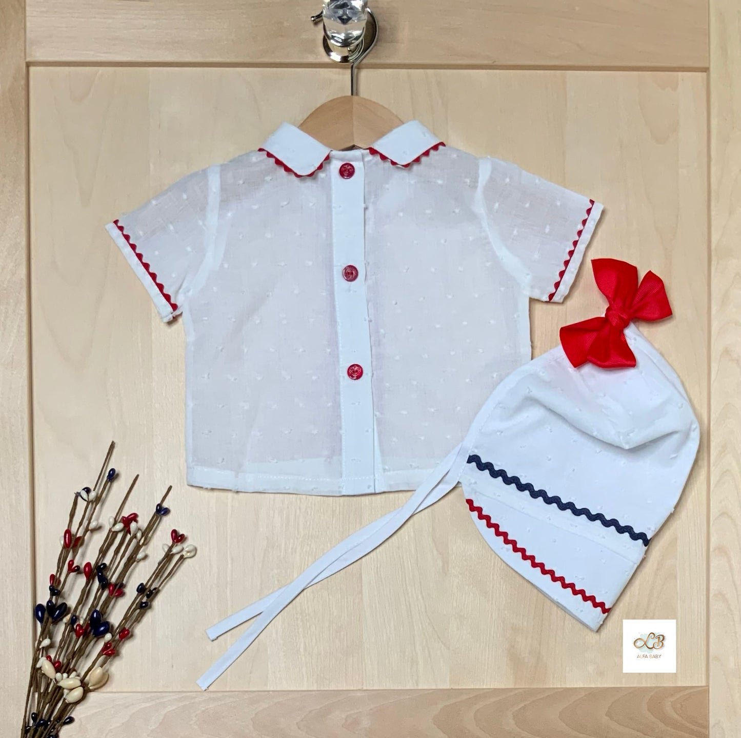 Back view of The Liberty red white and blue plumeti blouse showing button closure and matching bonnet  featuring large red bow— Alfa Baby Boutique